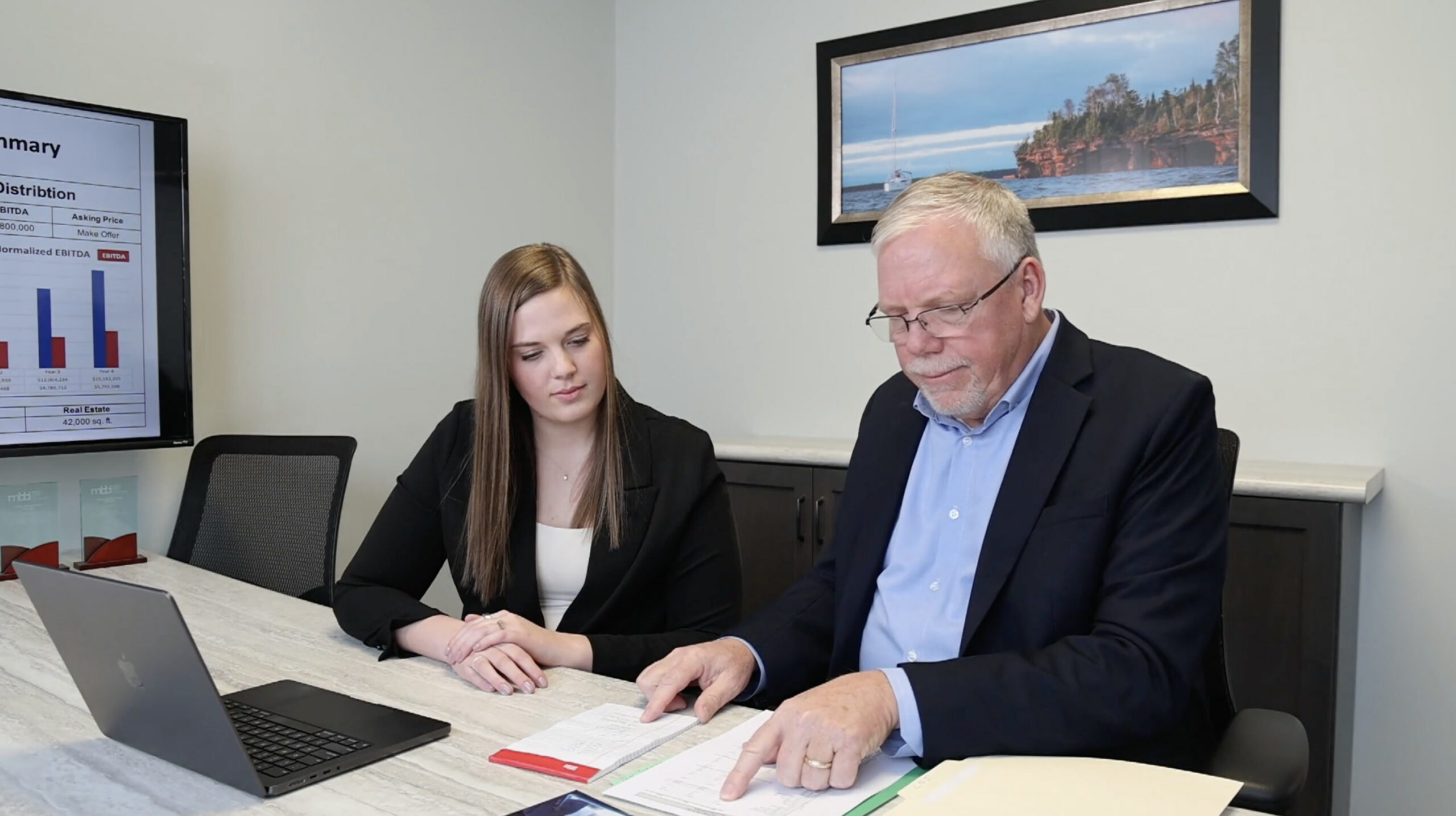 John Kelly & advisor reviewing seller documents